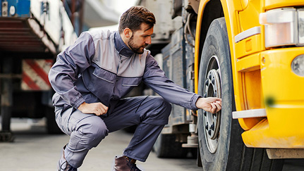 Man checking a vehicle's tires